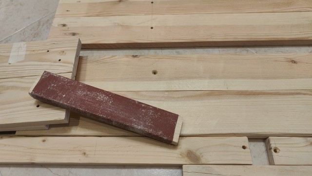 Semplice strumento di carteggiatura posato sulle tavole della mensola